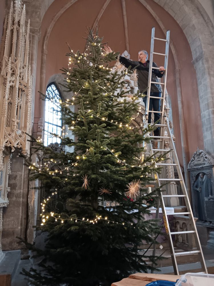 Pastor Gleitz schmückt den Baum in der Stiftskirche